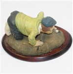 'History of Golf' Figure with Golfer Trying to Blow Ball in Hole