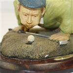 'History of Golf' Figure with Golfer Trying to Blow Ball in Hole