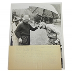 President Eisenhower Putting on Rain Gear with Sam Snead Holding Umbrella 7 1/8x9 Wire Photo